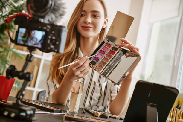 istock Choose it. Cute female blogger presenting a makeup palette and smiling while looking at camera 1132090281