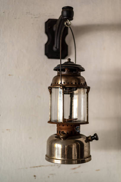 antique oil lamp hanging on a white wall - fire heat ornate dirty imagens e fotografias de stock