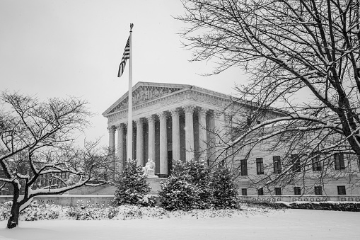 The U.S. Supreme Court building during a snowstorm, in black and white.