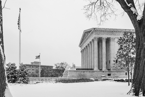 The U.S. Supreme Court building during a snowstorm, in black and white.