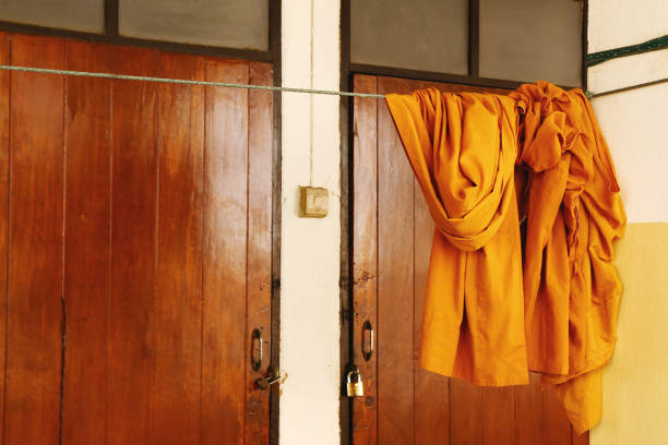 Monk's orange cloth hung on cloth line in Thai Buddhist temple.
