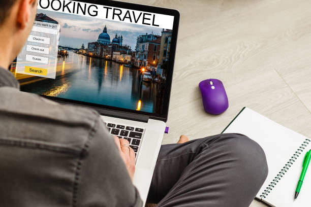 Man using a laptop and smartphone for booking hotel online. Tour reservation, Screen graphics are made up.