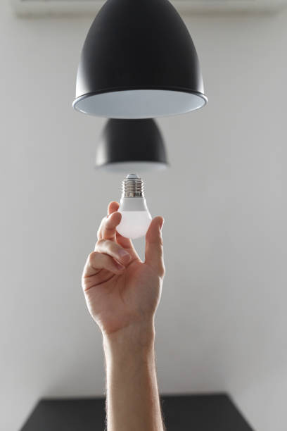 istock Changing the bulb for led bulb in floor lamp in black colour. On light gray background. 1132105227