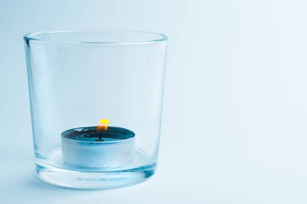 A lit candle in a glass candle holder
