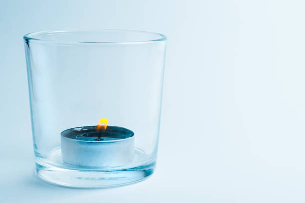 A lit candle in a glass candle holder A lit candle in a glass candle holder bicchiere stock pictures, royalty-free photos & images