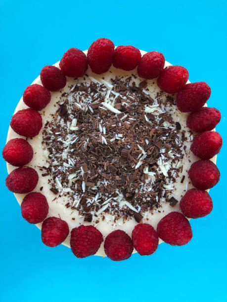 Image of whole gourmet homemade raspberry cheesecake cake dessert with grated chocolate and red berries