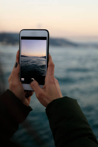 istock Holding a mobile smart phone outdoors 1132112790
