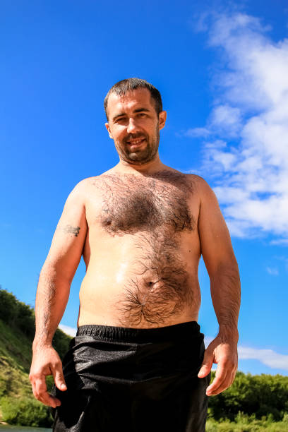 istock Hairy man with black beard and big belly against the sky 1132113499