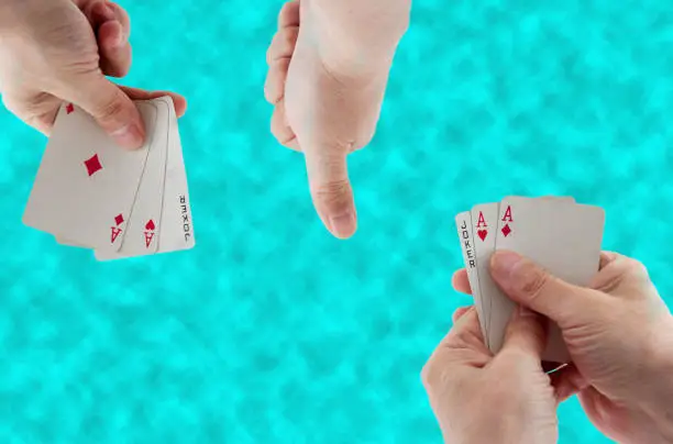 playing cards in hand on the background of the water in the pool