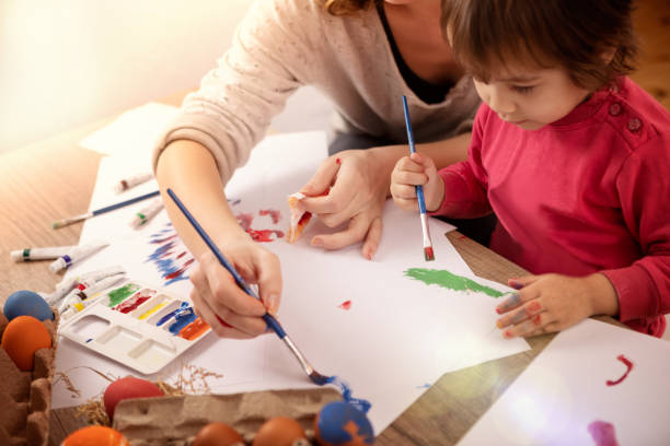 istock Little girl with mother makes Easter eggs 1132114194
