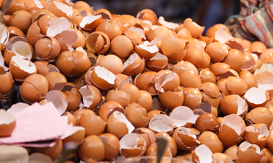 natural food ingredient, broken brown chicken egg shells in front of bakery shop in food market stall. Nutrition, Poultry Egg, Food, Wet Waste, Natural Protein, Calcium and Essential Minerals concept