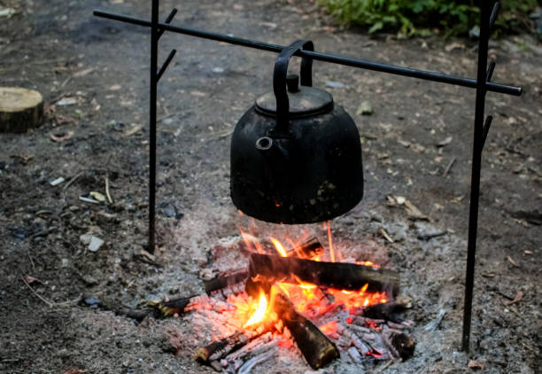 Rest on the nature, a black kettle is heated by water on a fire. Rest on the nature, a black kettle is heated by water on a fire. огонь stock pictures, royalty-free photos & images