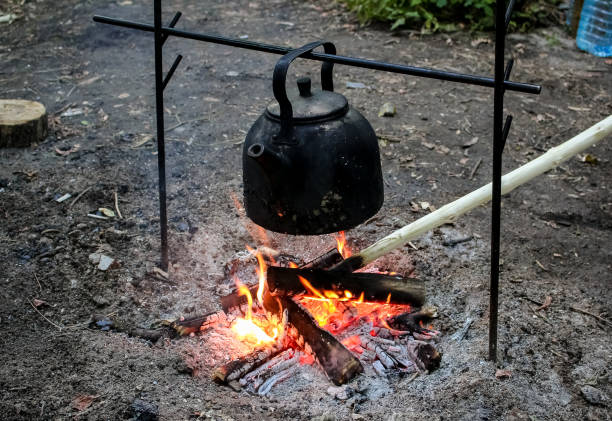 Rest on the nature, a black kettle is heated by water on a fire. Rest on the nature, a black kettle is heated by water on a fire. огонь stock pictures, royalty-free photos & images