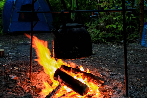 Rest on the nature, a black kettle is heated by water on a fire. Rest on the nature, a black kettle is heated by water on a fire. огонь stock pictures, royalty-free photos & images