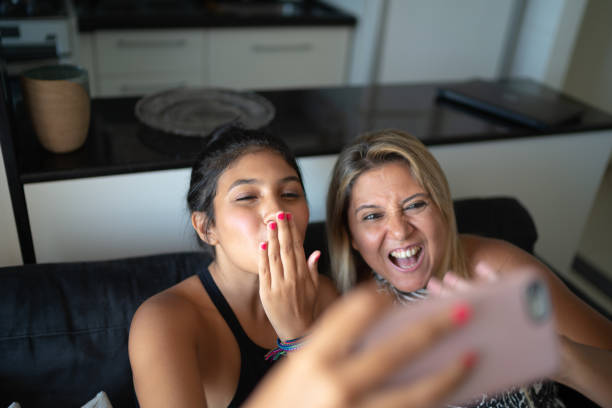 istock Mother and daughter having video chat while they are sitting on the sofa 1132119389