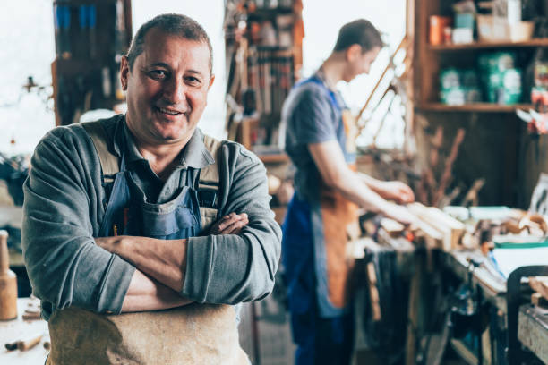 Craftsman in the carpentry workshop Portrait of Craftsman crossed arms in carpentry workshop carpenter portrait stock pictures, royalty-free photos & images