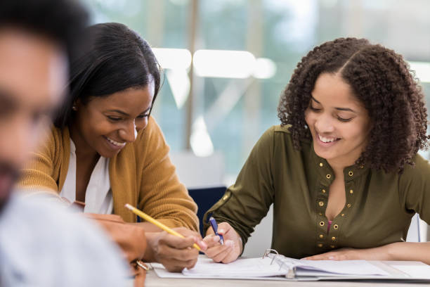 istock Female friends laugh while studying in college library 1132123680