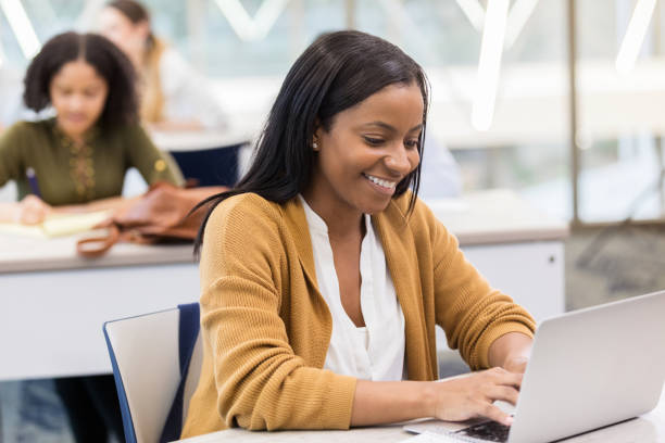 istock Cheerful female college student types on laptop in library 1132123979