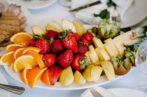 Fresh, exotic, organic fruits, light snacks in a plate on a buffet table. Assorted mini delicacies and snacks, restaurant food at event. Decorated delicious table for a party goodies.
