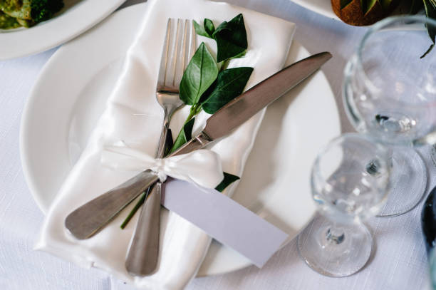 istock Serving, setting table. Two plates and silverware cutlery  linen napkin are decorated with pink ribbons and branch greens. Wedding table decoration. Artwork. flat lay. top view. Close up. 1132126369