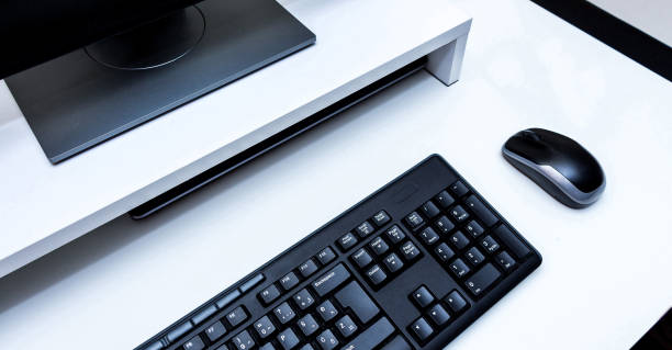 istock Computer wireless mouse, black monitor and keyboard on a white desk. 1132128328