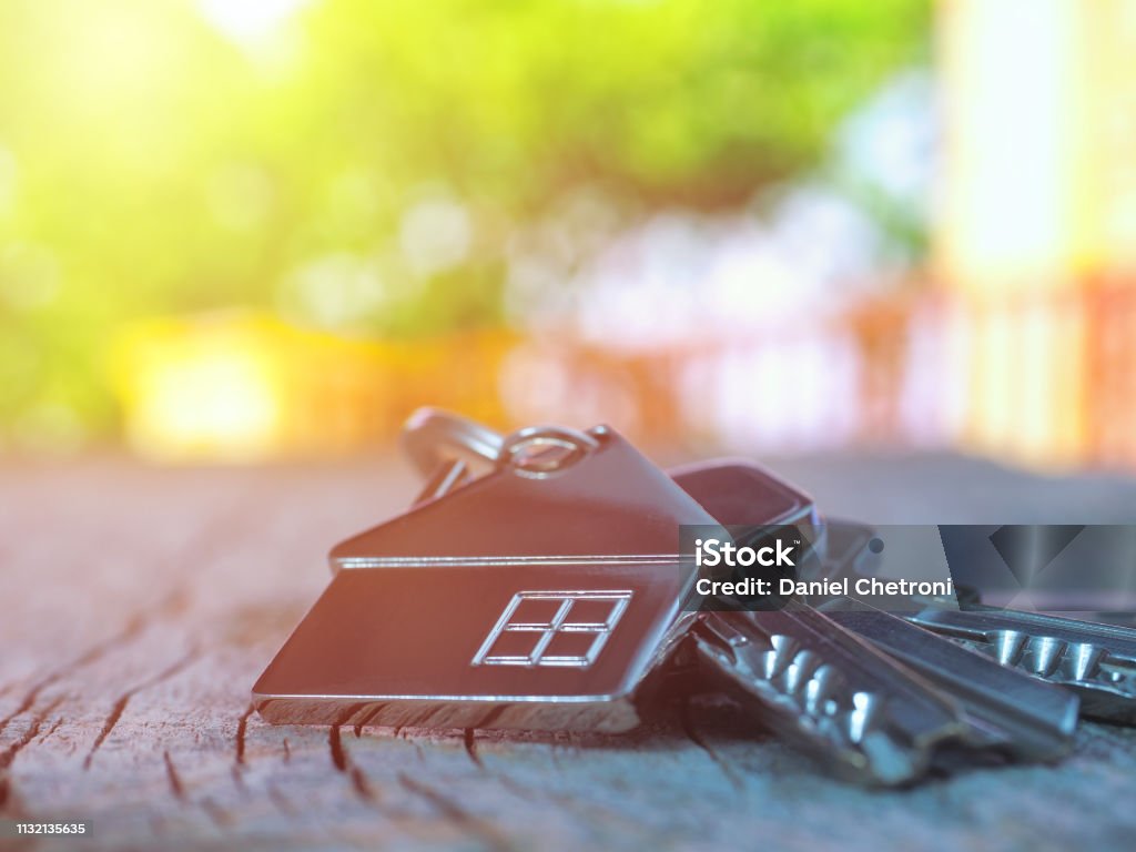 House keys with house figure on desk, out of focus background Key Stock Photo