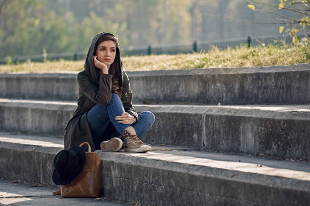 istock Young thoughtful woman sitting alone on staircase. 1132152824