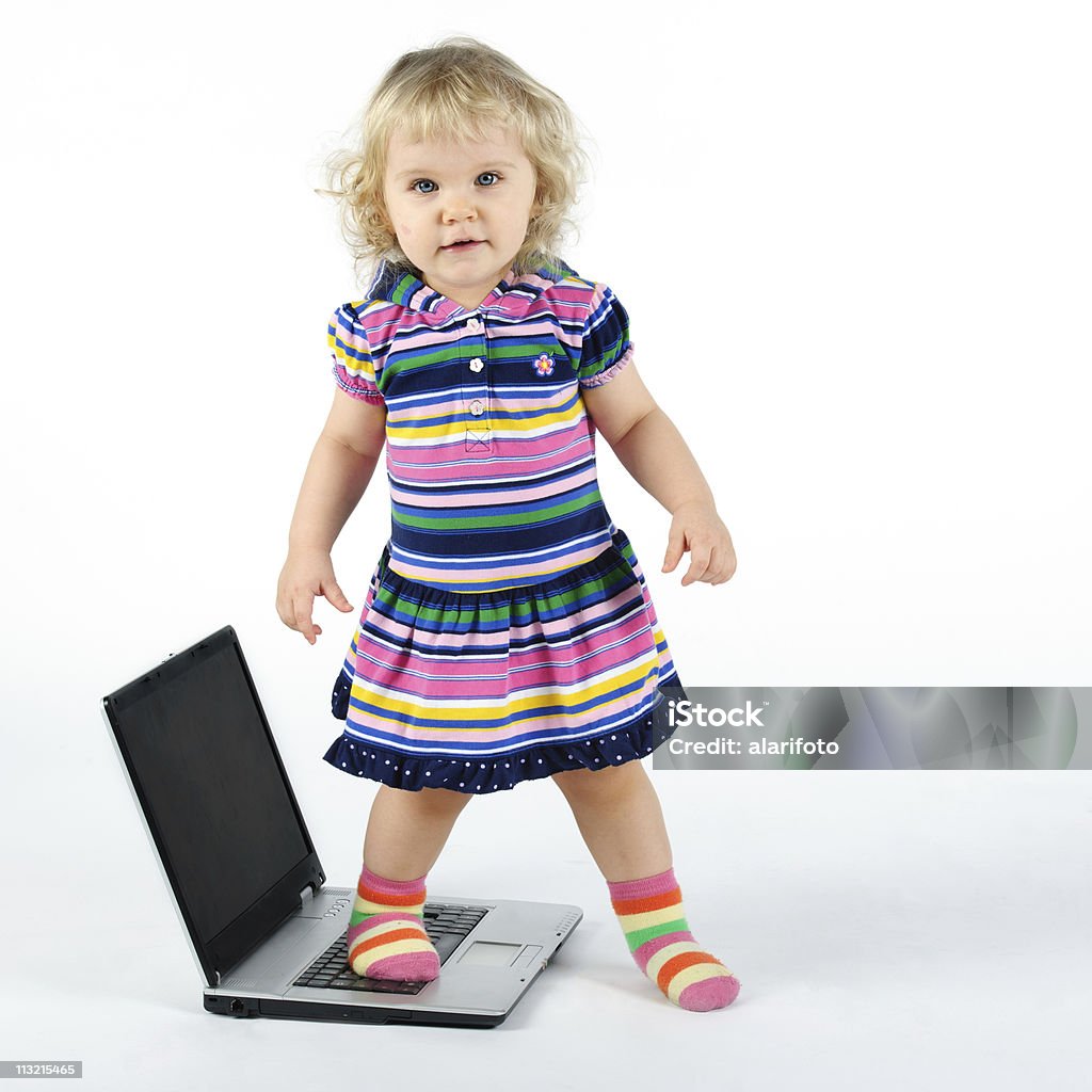 Girl and a computer A little girl stands on top of a computer Beautiful People Stock Photo