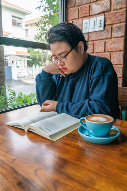 istock Asian girl reading book and drinking coffee 1132159343