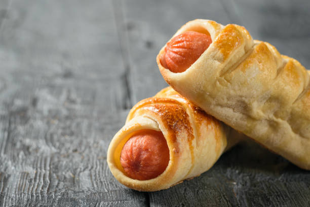 istock Two homemade sausage rolls on a rustic black table. 1132173162