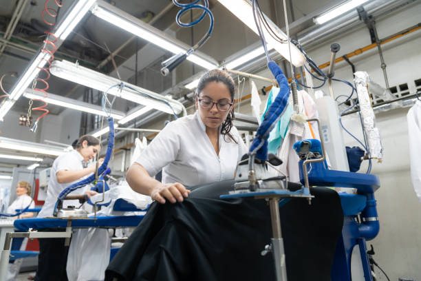 istock Focused women working at a laundry service ironing clothes 1132178352
