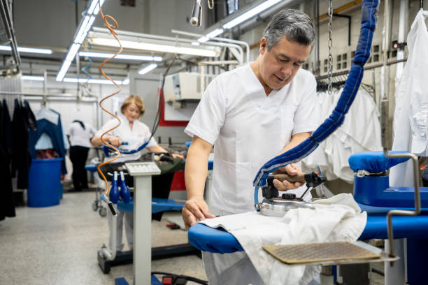 istock Male blue collar worker at a laundromat ironing clothes 1132178374