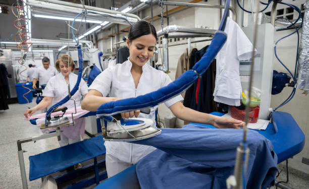 istock Workers at a dry cleaning service ironing clothes smiling 1132178390