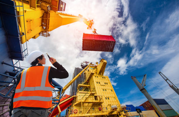 Loading at risk foreman, supervisor, worker, loading master in works at job site, control to the teamwork by walkie talkie radio for job done in the same direction, working at risk and high level of insurance gantry crane stock pictures, royalty-free photos & images