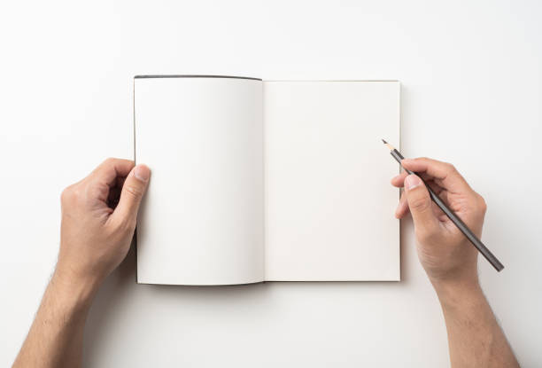 istock man hand hold brown notebook and pen on white 1132182619