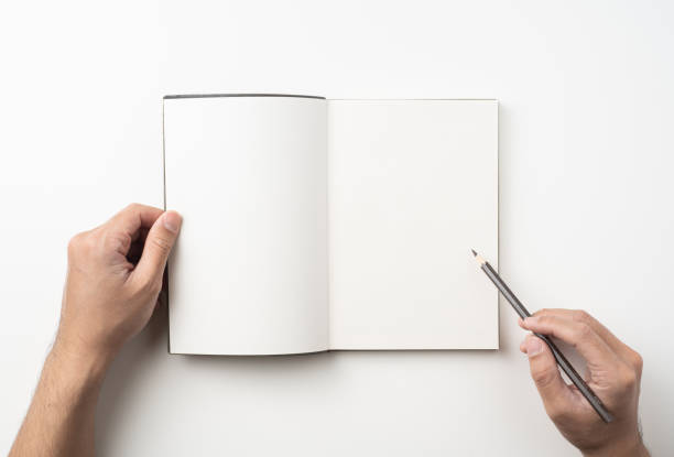 istock man hand hold brown notebook and pen on white 1132182629