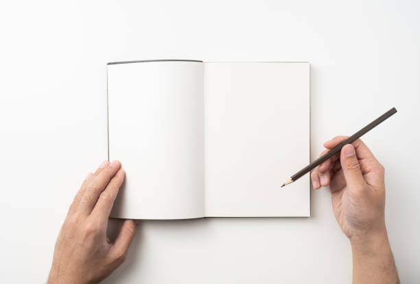 istock man hand hold brown notebook and pen on white 1132182648