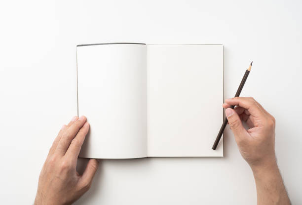 istock man hand hold brown notebook and pen on white 1132182659
