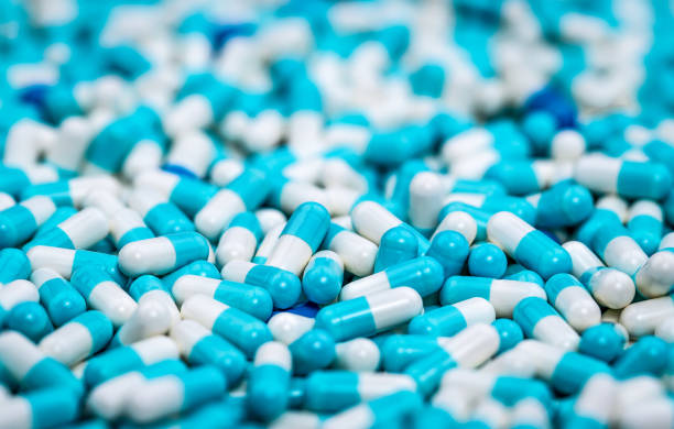 青と白の抗生物質カプセルの丸薬の山に選択的焦点.医薬品生産。グローバルヘルスケア。抗生物質の薬剤耐性。抗菌カプセルの丸薬.製薬産業。 - amoxicillin ストックフォトと画像