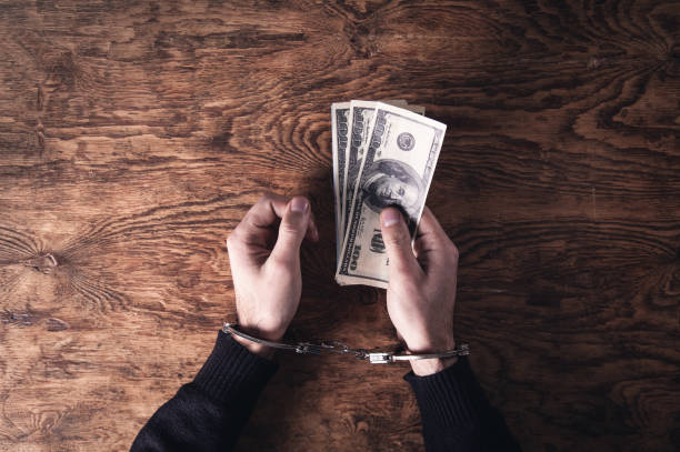 istock Hands in handcuffs holding dollar banknotes. Corruption 1132186865
