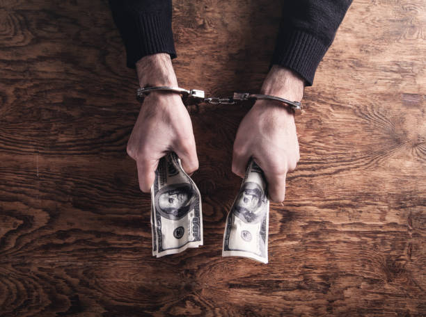 istock Hands in handcuffs holding dollar banknotes. Corruption 1132186869