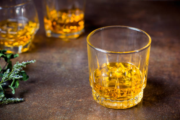 istock glasses of whiskey with ice cubes  on  bar. 1132187896