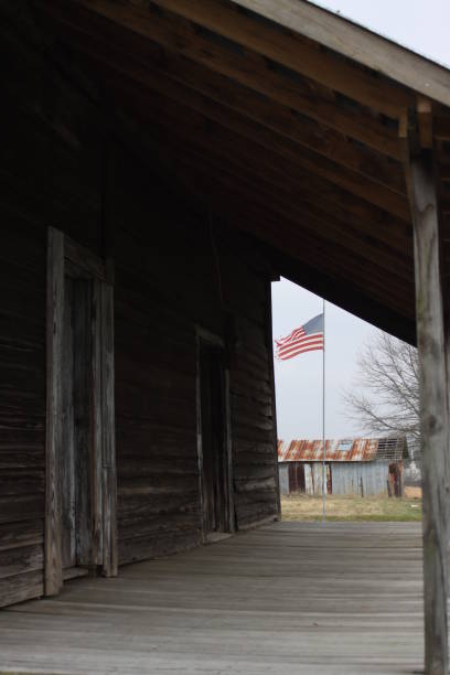 istock abandoned cabin, american flag, weathered wood 1132190782