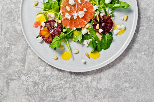 istock Salad with arugula, grapefruit, red oranges, nuts and cheese. Gray background, top view, space for text. 1132192468