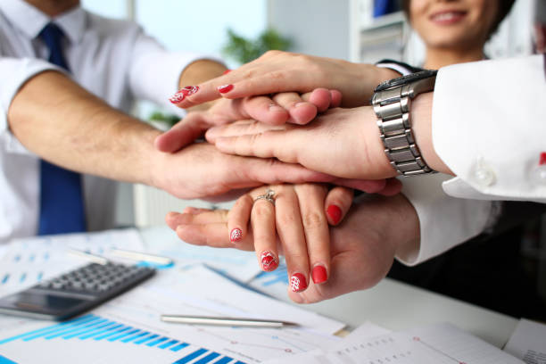 istock Group of people in suits crossed hands in pile 1132192599