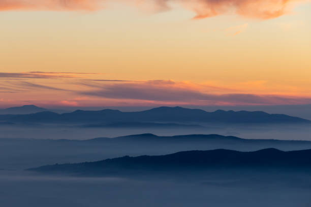 istock Beautifully colored sky at dusk, with mountains layers and mist between them 1132200466