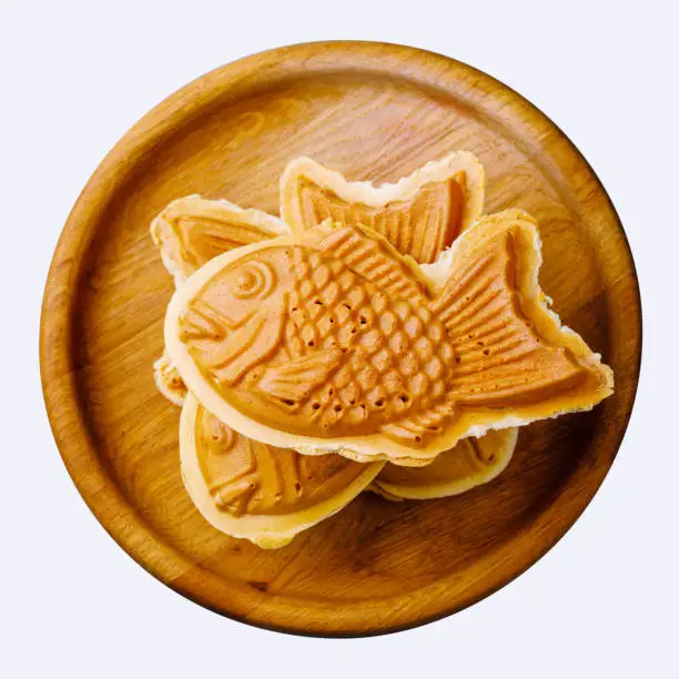 Taiyaki Japanese street food fish-shaped sweet filling waffle on wooden plate