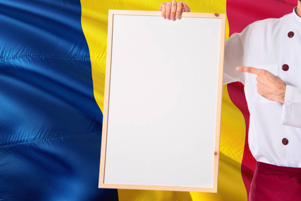 Chadian Chef holding blank whiteboard menu on Chad flag background. Cook wearing uniform pointing space for text.