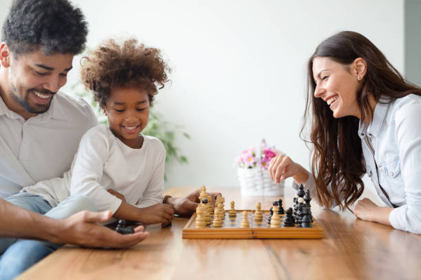 istock Happy family playing chess together at home 1132206435