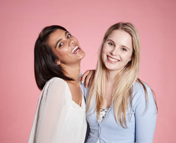 istock Two pretty girlfriends, one blonde, one Asian, laugh together 1132207073